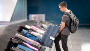 Young handsome man passenger in 20s with carry-on backpack 